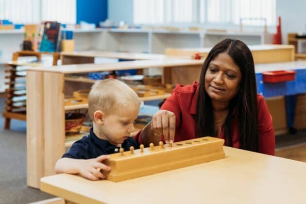 Woman teaching little boy how to play a game.